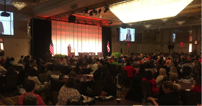 Scene at Convention Ballroom; Banner on Podium: Bold Mission Bright Future